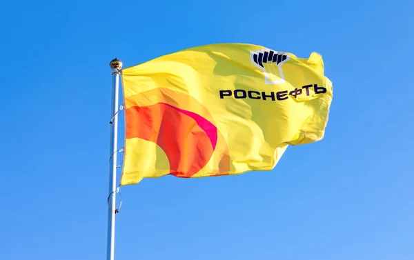 Флаг компании Роснефть против голубого неба — стоковое фото